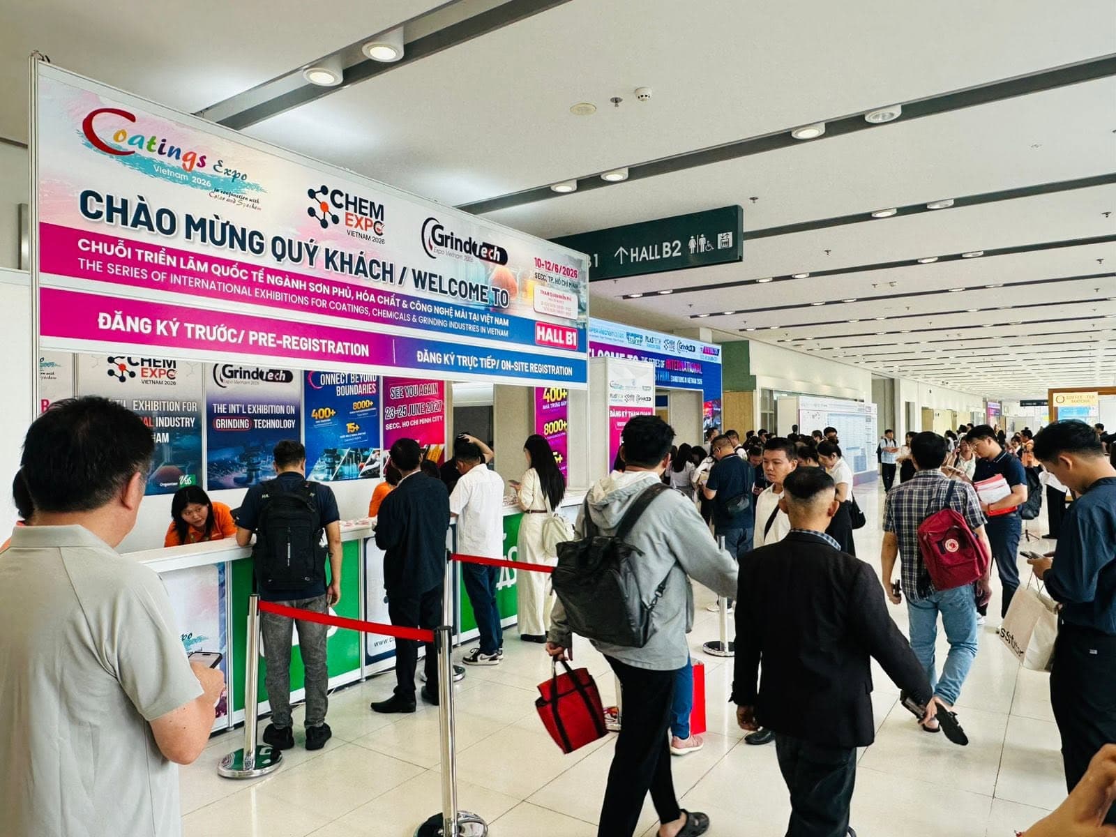 Registration hall for Coatings Expo Vietnam, a full-width welcome banner above busy pre-registration desks