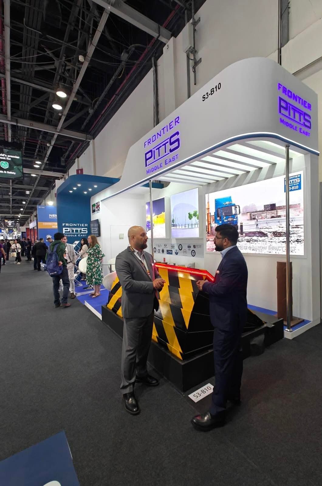 Frontier Pitts Middle East stand, a curved white fascia over a road-blocker exhibit and backlit project panels