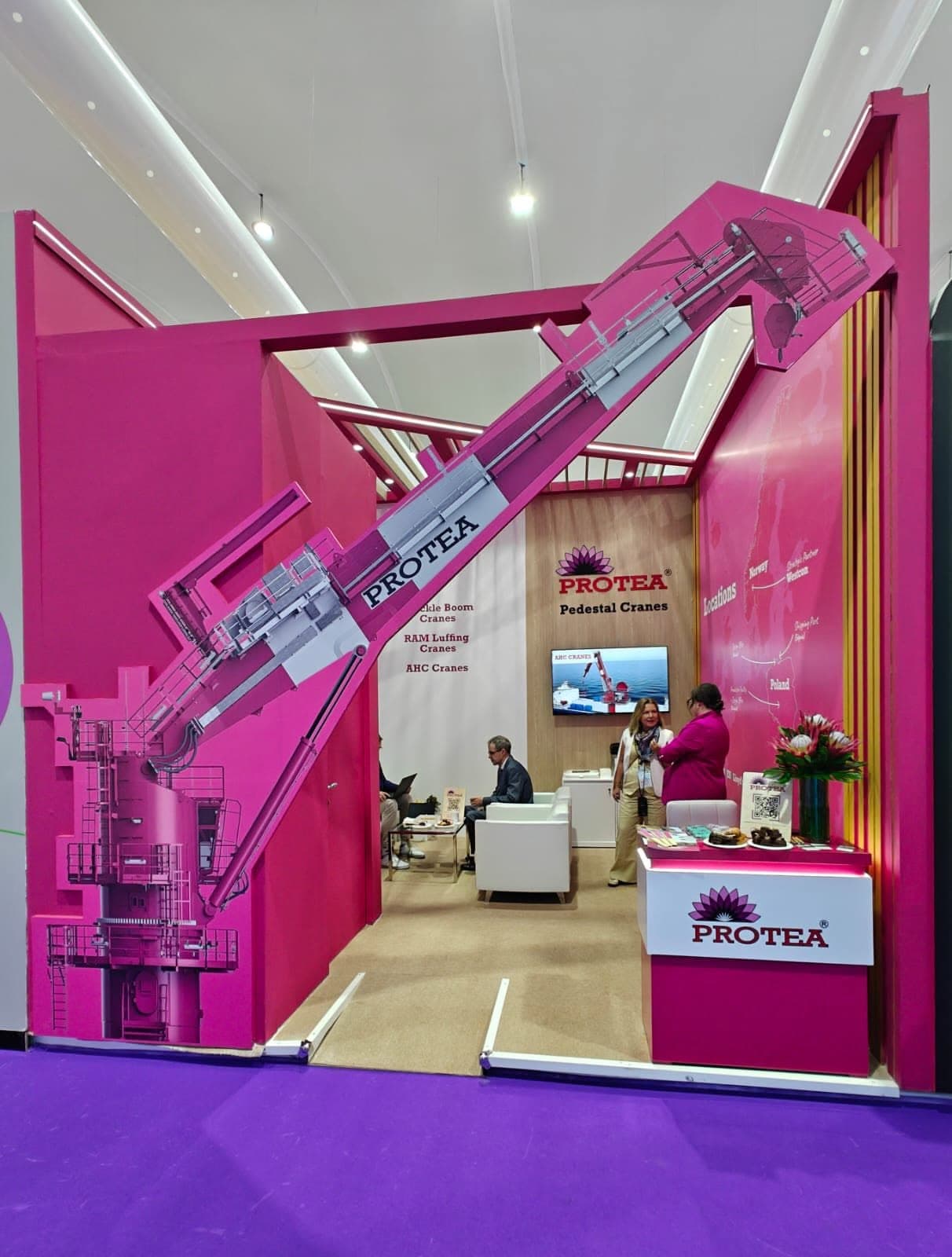 Protea pedestal-crane stand, a full-height magenta wall carrying a life-size crane graphic over a timber meeting area