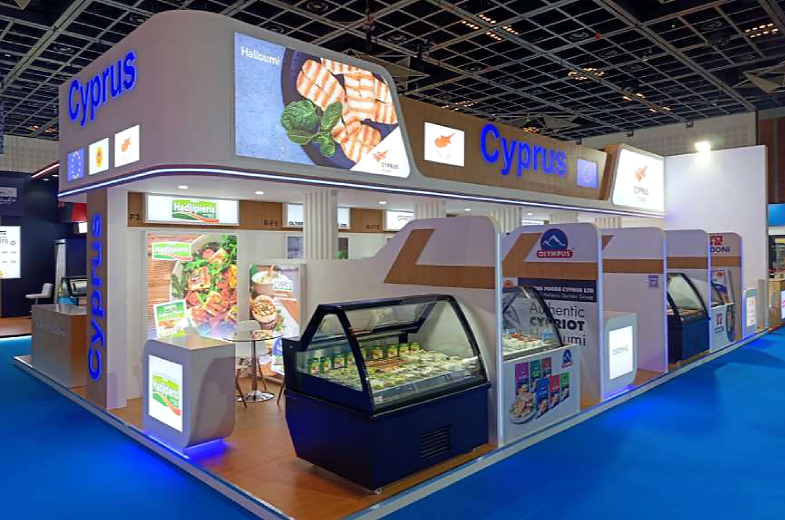 Cyprus national food pavilion at Gulfood with refrigerated halloumi showcases and a backlit overhead fascia
