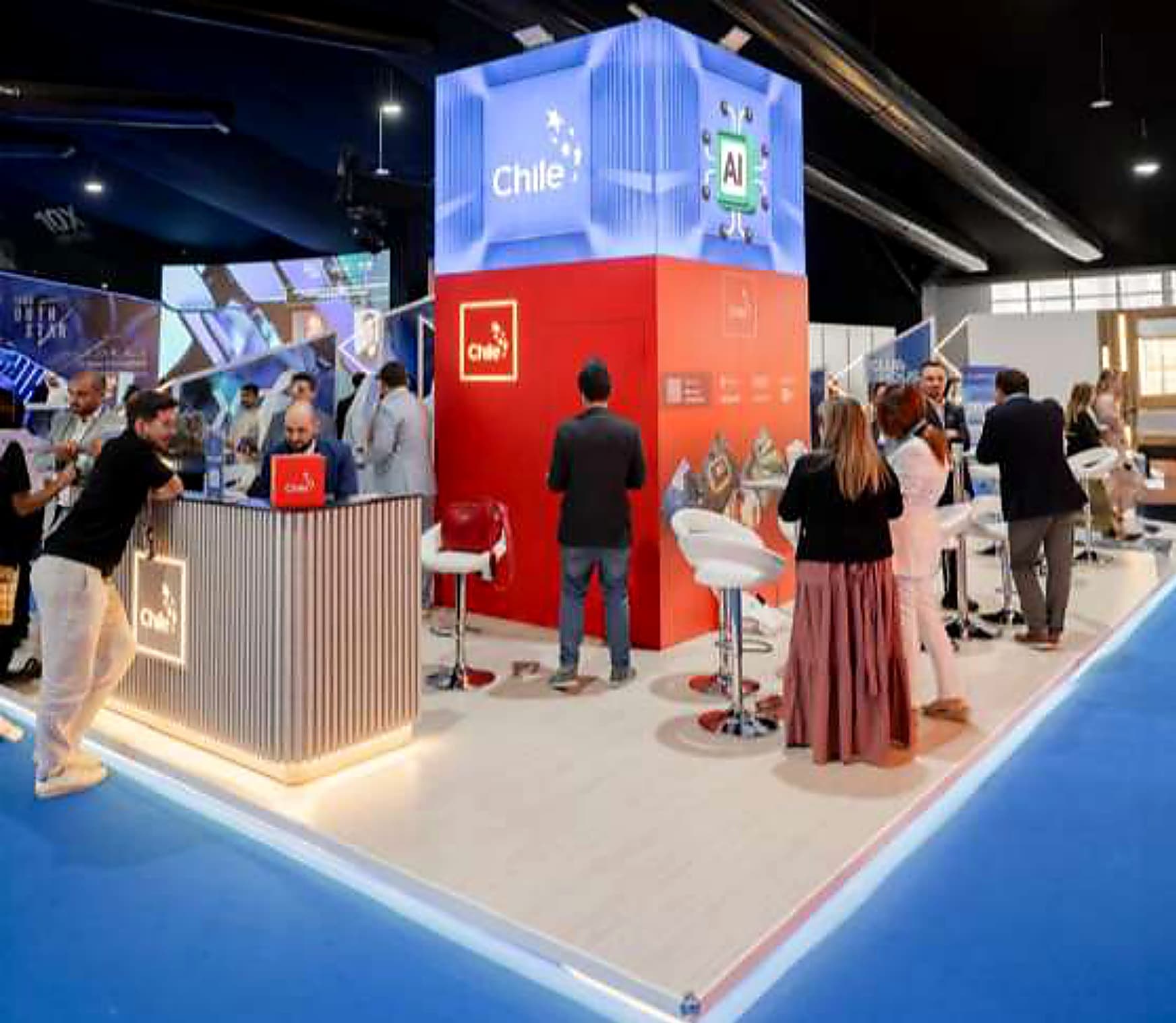 Two-tone island tower stand in red and blue with a reception counter and bar seating in use