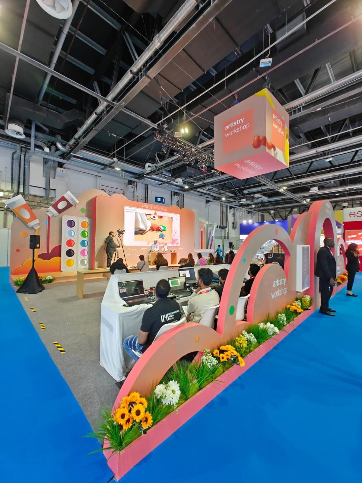 Live workshop activation stage with arched scenery facing a seated demonstration audience